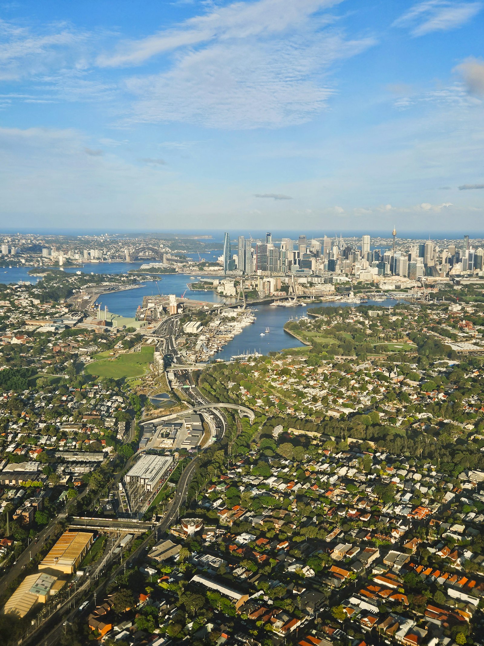 Aerial view across the suburbs of Sydney toward the city